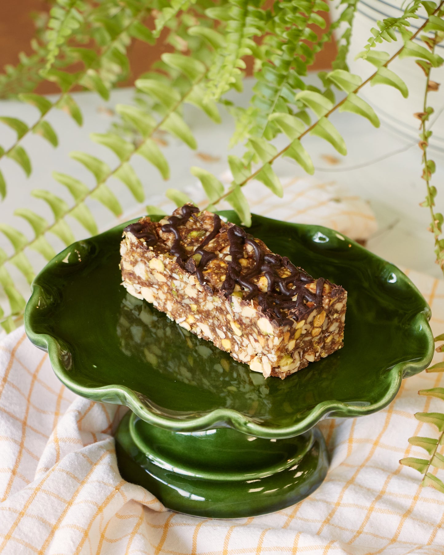 Close-up view of a high-fibre, high-protein energy bar highlighting the dense mix of pumpkin seeds, almonds, pistachios and sunflower seeds.