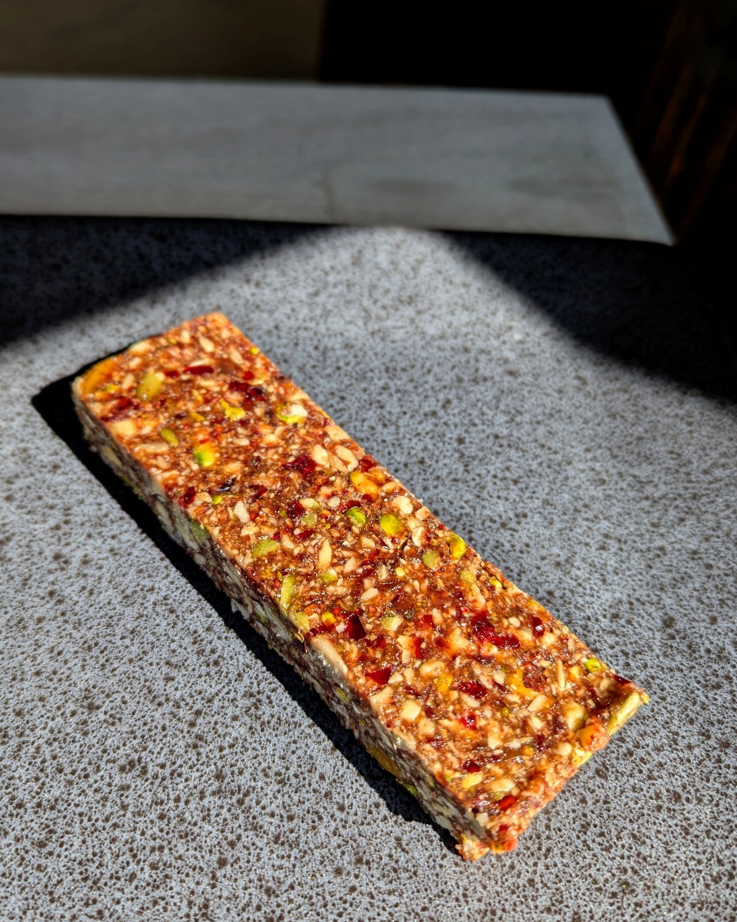 Rectangular cranberry protein bar with visible oats and nuts, clean-label, nutritious, family-friendly Canadian snack.